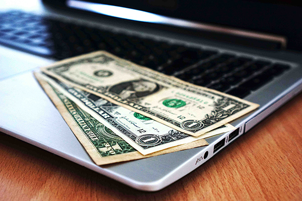 US dollar bills on a computer - Photo by Pixabay: https://www.pexels.com/photo/1-us-dollar-bill-163056/